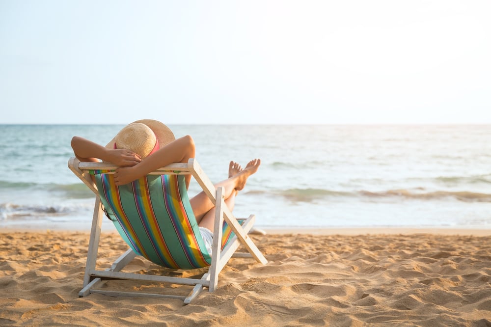 person in lounge chair on the beach