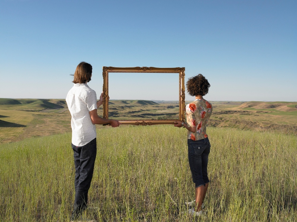 Two people looking through a frame