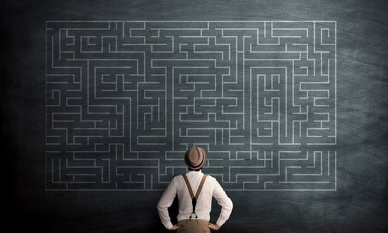 man in front of chalkboard maze