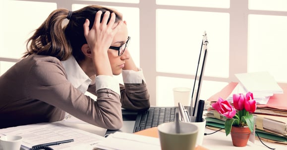 overworked woman at her desk shutterstock_129618488